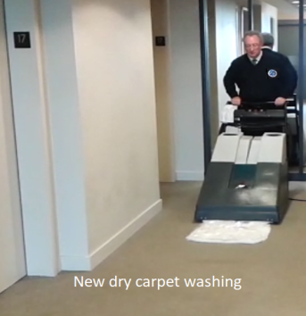 A man pushing a dry carpet machine in an office building