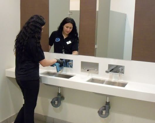 Women worker cleaning an office bathroom