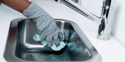 Worker cleaning an office kitchen sink