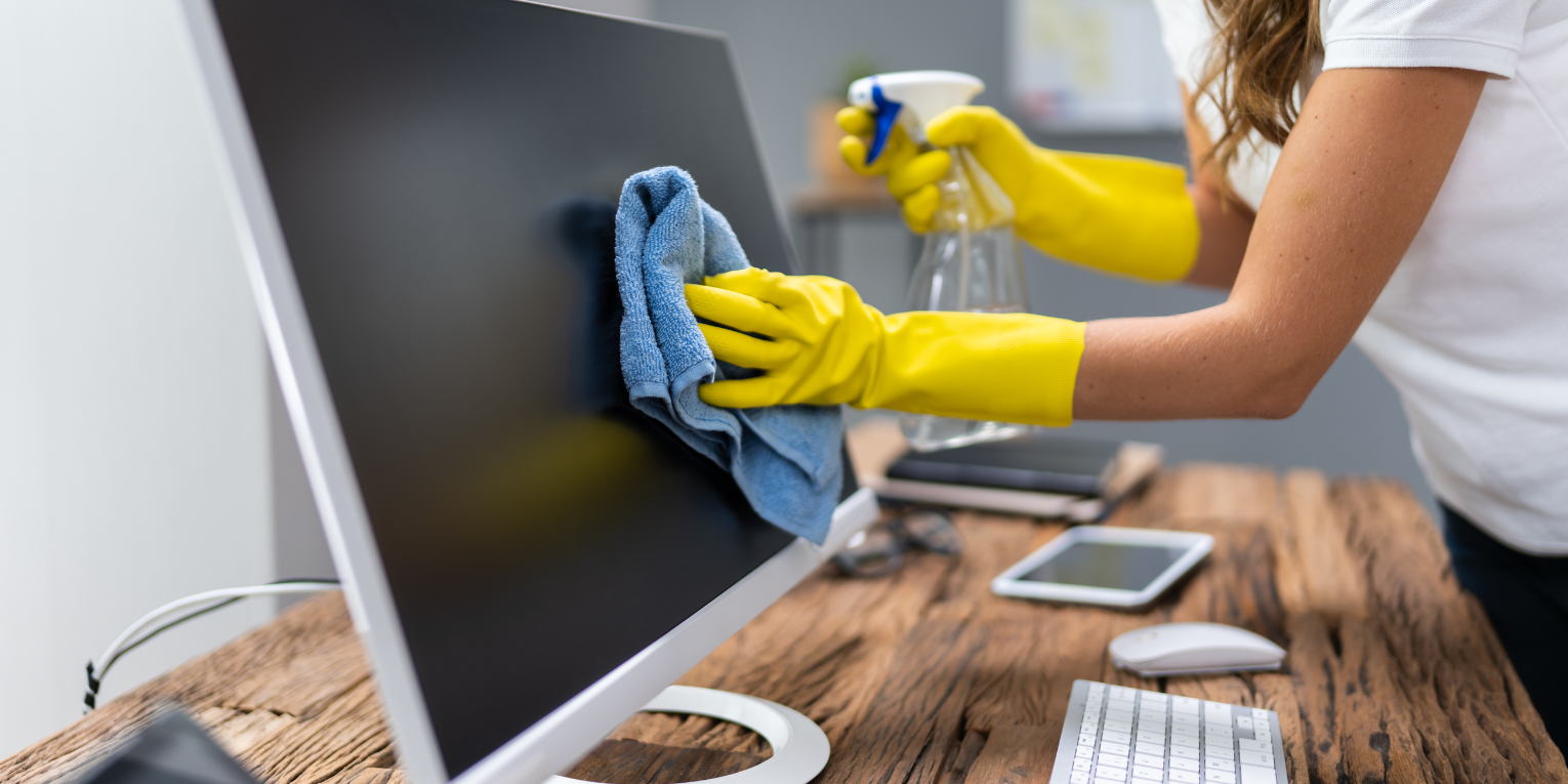 A Worker cleaning a screen of a computer